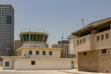 Old Airport Control Tower Structure Against Modern Skyscrapers in the City of Sharjah, United Arab Emirates