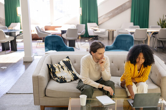 Two colleagues brainstorming ideas together in a modern space