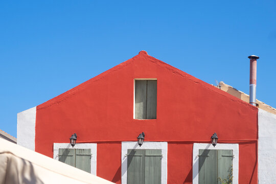Red house, white wall and blue sky composition