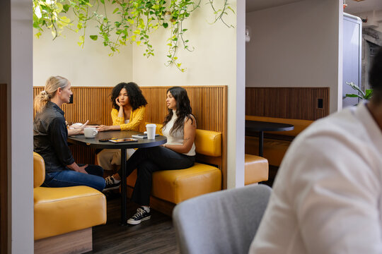 Group discussing ideas over coffee in a modern cafe