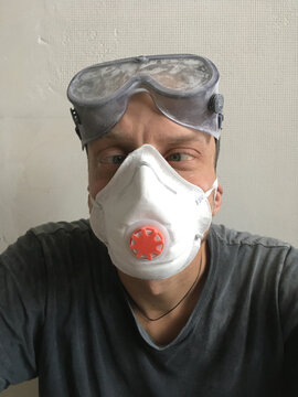 Close-up of man wearing respirator and safety goggles