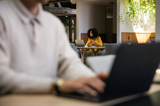 Diverse individuals working on laptops in a modern open office