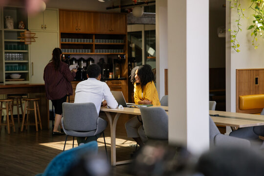 Colleagues enjoy a casual meeting in a cozy office break area