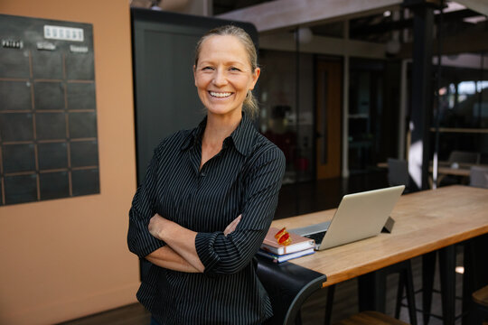 Confident mature businesswoman smiling in a modern office setting