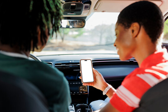 Woman passenger holding smartphone with blank screen in car