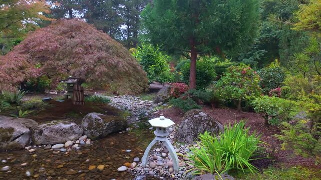 A tranquil and picturesque view of Tsuru Island (Crane Island) within the Gresham Japanese Garden, surrounded by calm water and vibrant, colorful autumn foliage in Gresham, Oregon