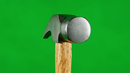 A close-up of a hammer on a wooden handle against a green backdrop - Powered by Adobe