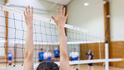 Volleyball Player Blocking at the Net with Hands Raised