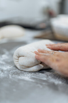 Close-up of hands folding soft bread dough