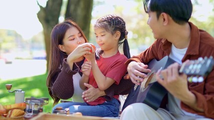 A family collects trash bottles at a park. - Powered by Adobe