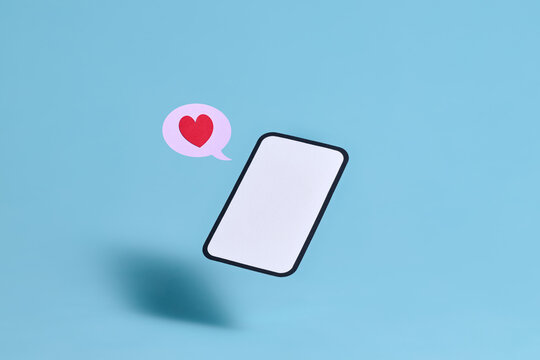A floating smartphone sends a digital love message with a red heart