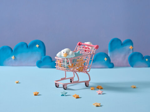 A cloud eraser rides in a pink shopping cart, sprinkled with stars