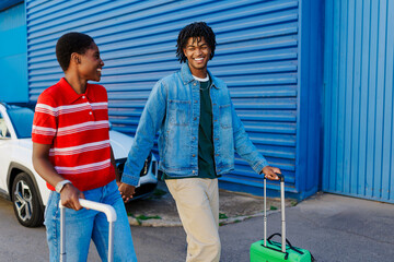 Smiling couple pulling suitcases ready for journey