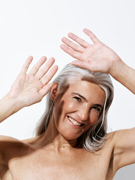 Smiling Mature Woman With Gray Hair Shields Her Face