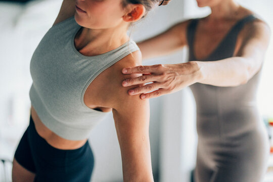 Woman Practicing Yoga Pose with Instructor's Guidance