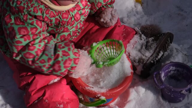 Child playing in the park on winter day having fun and wallowing in the snow, she walking in snow on nice winter day, enjoy being outside