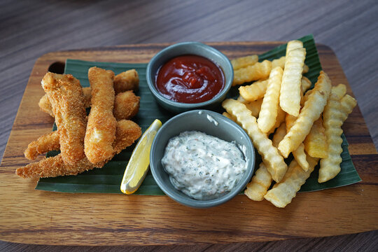 Close up plate of fish and chips with Tartare sauce and Ketchup- British cuisine