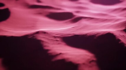 Abstract flowing purple and pink liquid or fabric texture with soft waves and subtle shadows creating a mesmerizing and dynamic background loop.