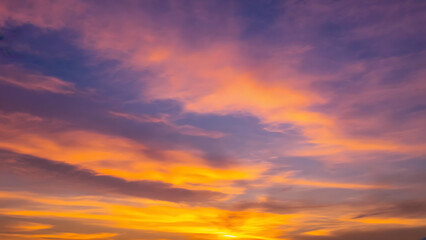 Vibrant Sunset Sky with Fiery Orange Clouds and Deep Purple Hues