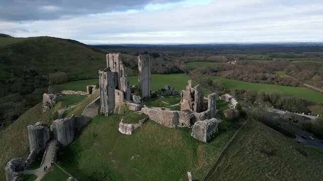 Aerial Drone Footage of Corfe Castle in England &mdash; Historic Medieval Ruins, Scenic Countryside Views, and Dramatic Ancient Landmark Rising Above the Landscape
