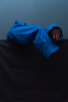 Man Dressing in Blue Against Tonal Backdrop