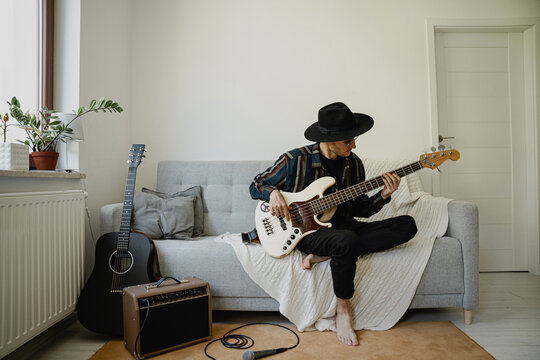 Singer sing sons and playing on guitar at home.