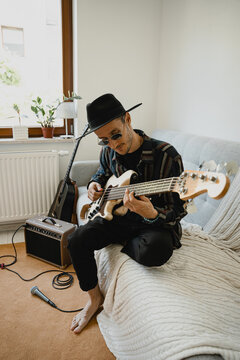 Singer sing sons and playing on guitar at home.