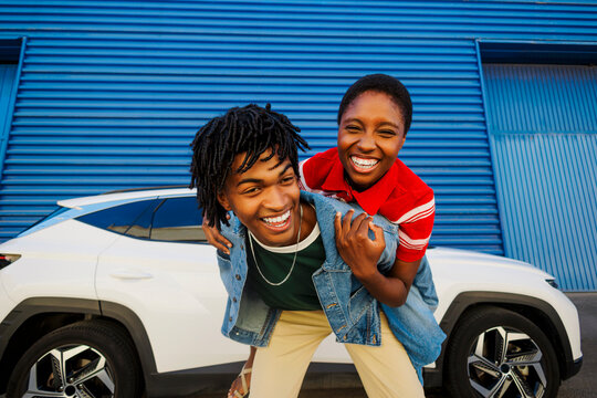 Happy friends giving piggyback ride in urban setting