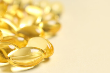 Vitamin E capsules on beige background, closeup