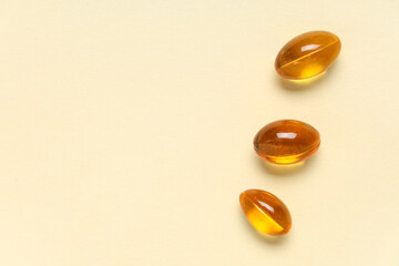 Vitamin E capsules on beige background