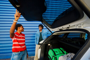 Couple packing car trunk for summer road trip