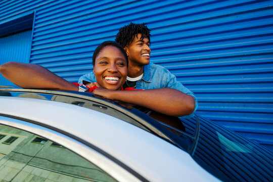 Couple enjoying car sunroof traveling together