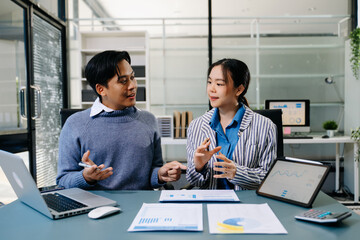 Businesswomen work and discuss their business plans. A Human employee explains and shows her colleague the results paper