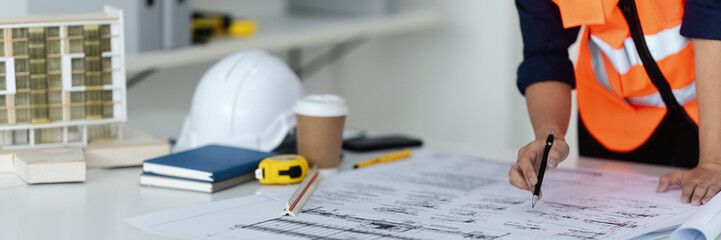 Site engineer planning projects with blueprint in indoor office