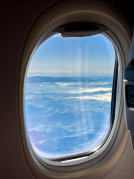 Clouds and Mountains View From Airplane Window During Daylight