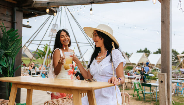 Young women sharing a drink moment at beach bar