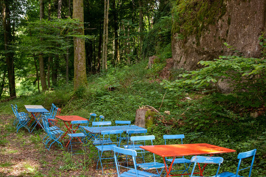 Colorful seating area with tables and chairs in a forest