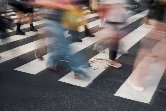 Crowd crossing urban street on zebra lines