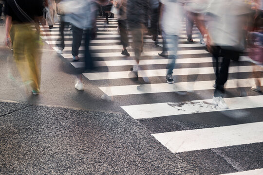 Crowd crossing urban street on zebra lines
