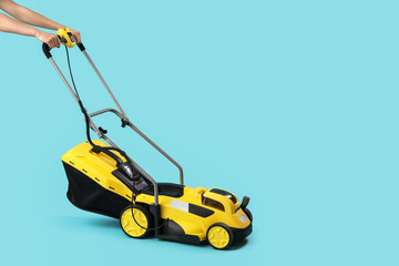 Naklejka premium Modern lawn mower on blue background