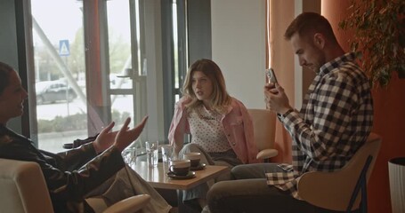 Business professionals are having a casual meeting at a modern cafe. They are networking, discussing ideas, and engaging with mobile technology for social media or content creation. - Powered by Adobe