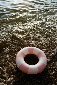 Pink and white life ring on a seashore