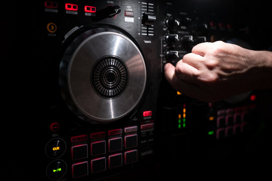 DJ mixing tracks with electronic music controller. Close-up of DJ turntable sound mixer in nightclub. Music producer DJ rhythm and sound. Sound mix. DJ controller. Electronic music. Club mixing music.