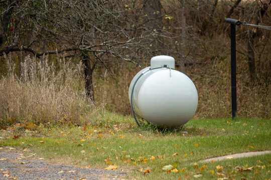 A steel propane tank in the yard