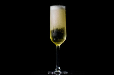 Festive pour of champagne with bubbles. Champagne glass shining with effervescent bubbles. Sparkling wine with bubbly champagne in wine glass.