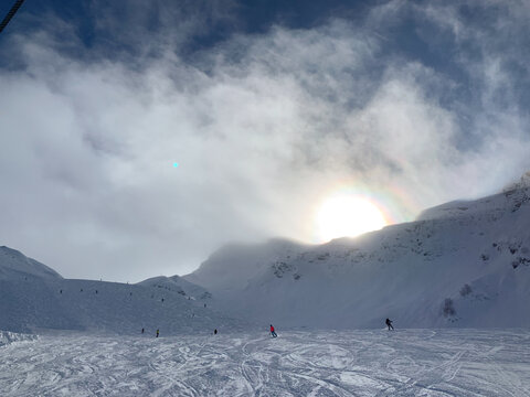 Skiers on snowy slope under bright winter sun
