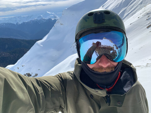 Self portrait of snowboarder in snowy mountains