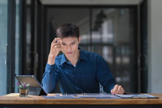 Young man thinking at desk, finding solution