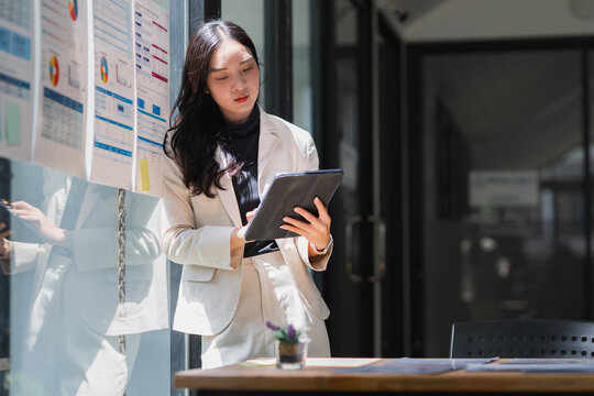Young business woman analyzing data using tablet