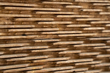 Textured background of a stacked natural stone wall. Brown and grey slate veneer panels with selective focus. Modern cladding design
